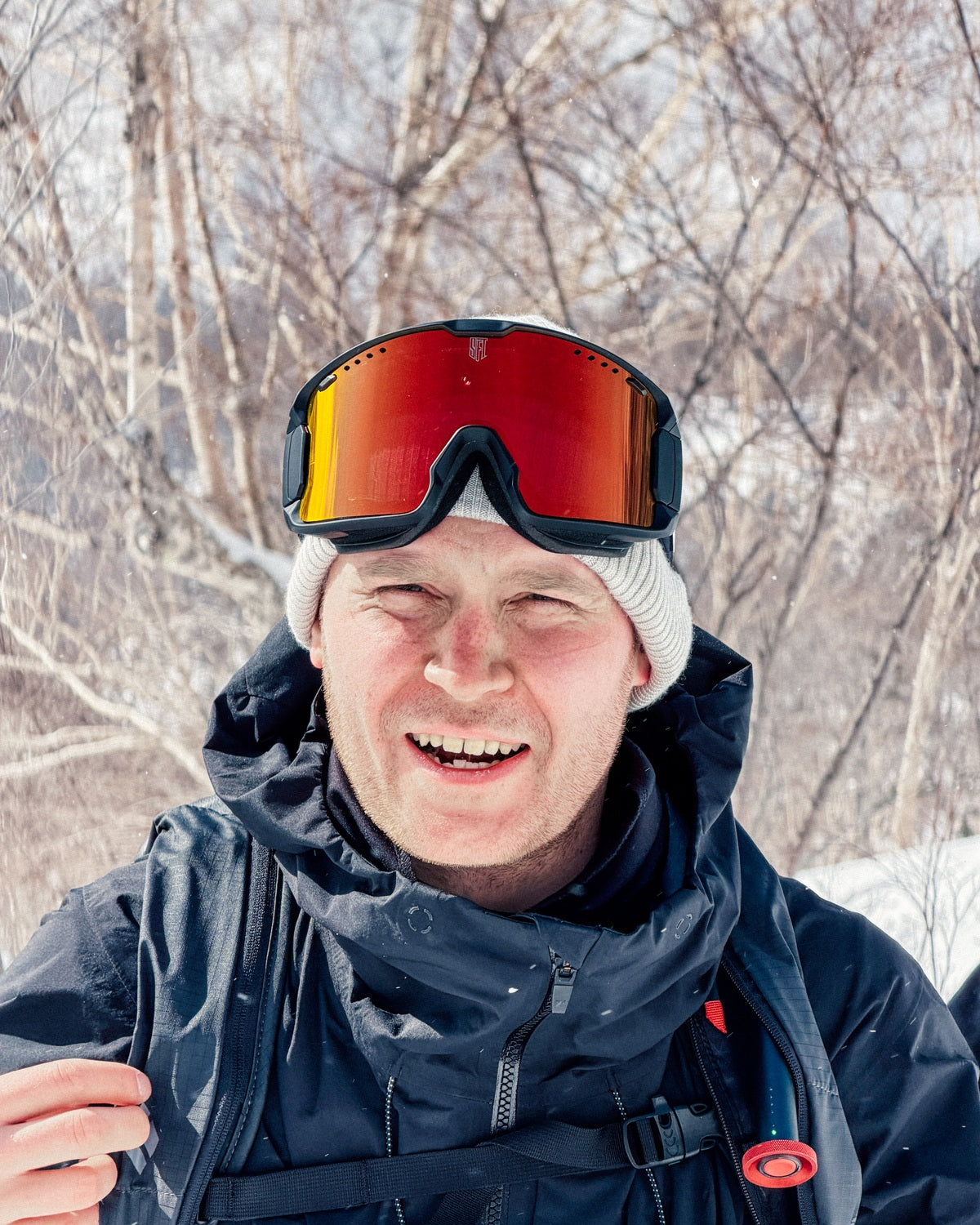 Snowboarder smiling with red SFT CLIP goggles
